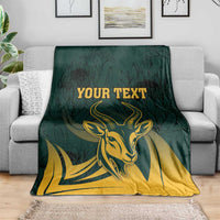 Green South Africa personalized blanket neatly draped with gold springbok head, protea leaf pattern