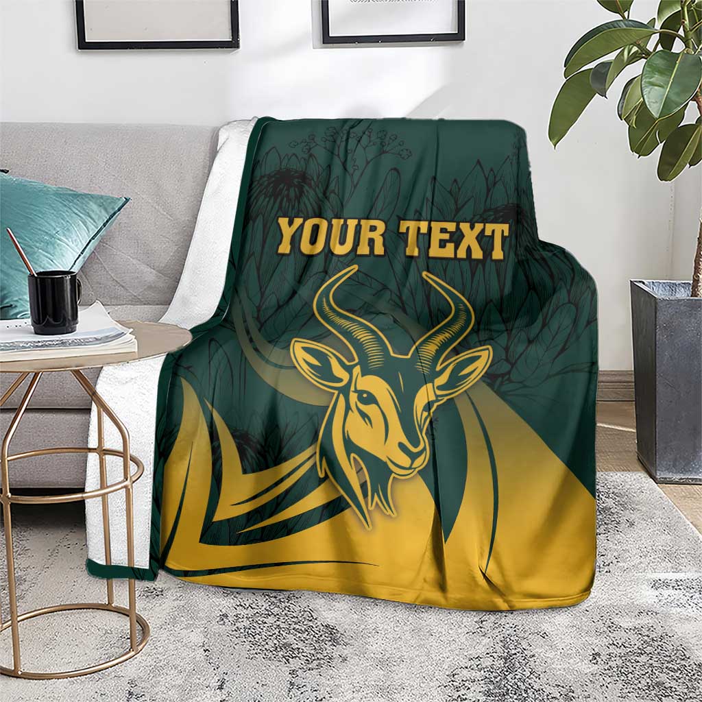 Green South Africa personalized blanket on sofa with gold springbok head and protea leaf pattern