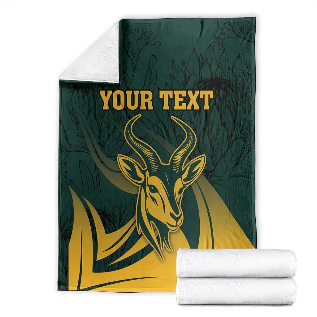 Folded green South Africa personalized blanket with gold springbok head, protea leaf pattern