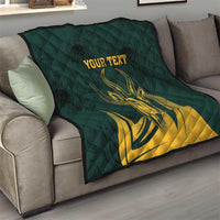 Green quilt on gray sofa featuring yellow springbok graphic and customizable text