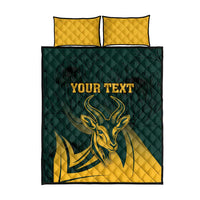 Green and gold quilt bed set with bull emblem and two yellow quilted pillows