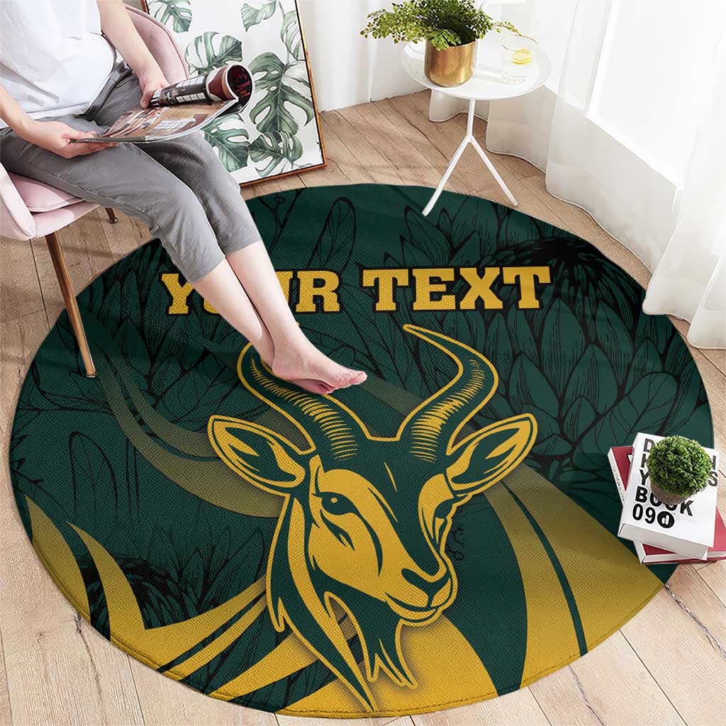Round green carpet featuring a gold springbok head over leafy pattern and "YOUR TEXT"