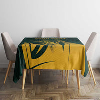 Green tablecloth with gold antelope illustration and dark botanical pattern