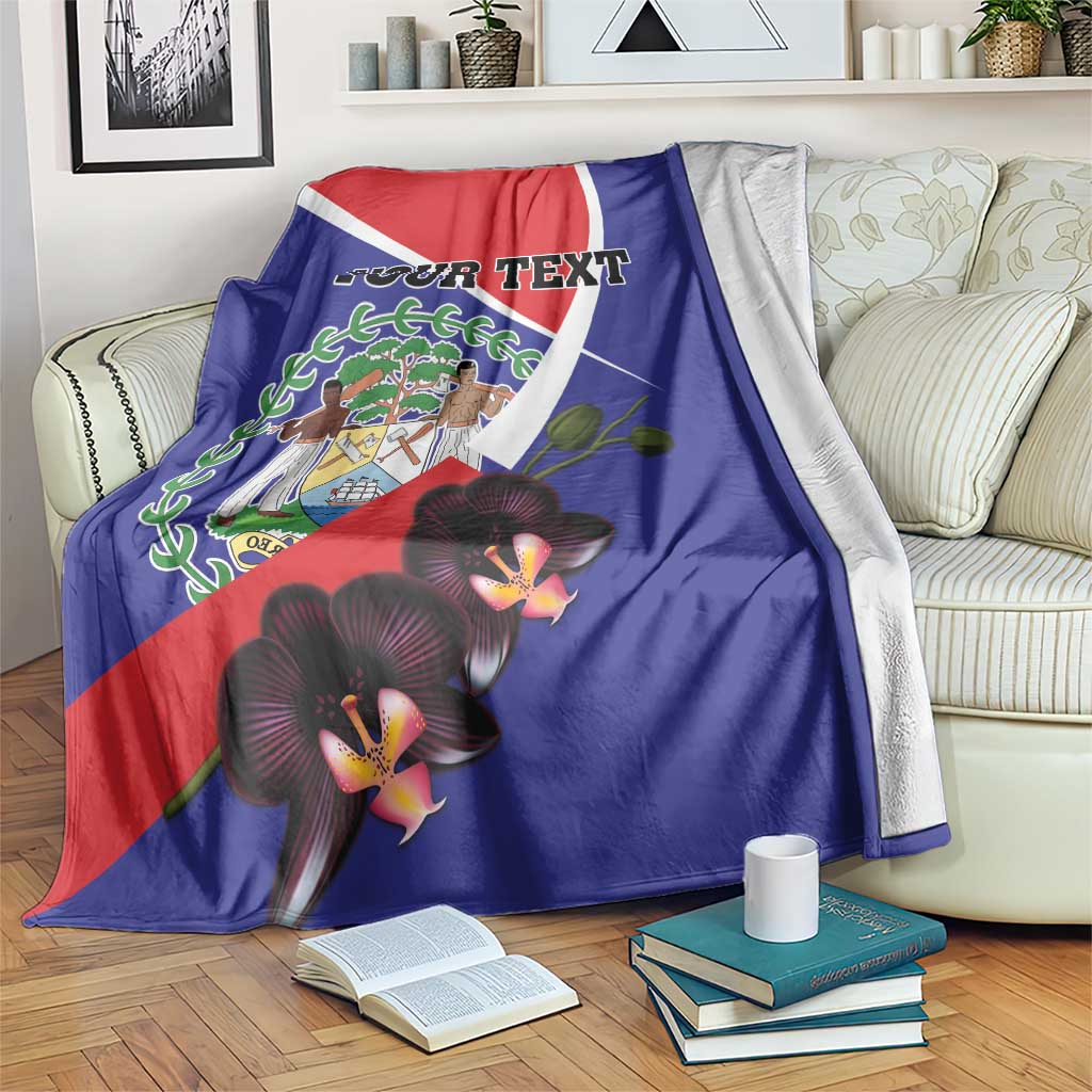 Blue Belize blanket over couch arm, 'YOUR TEXT' print, coat of arms and orchids.