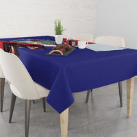 Blue tablecloth with orchid and Belize coat of arms style artwork on dining table.
