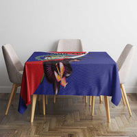 Blue tablecloth featuring orchid and coat of arms design across dining table.