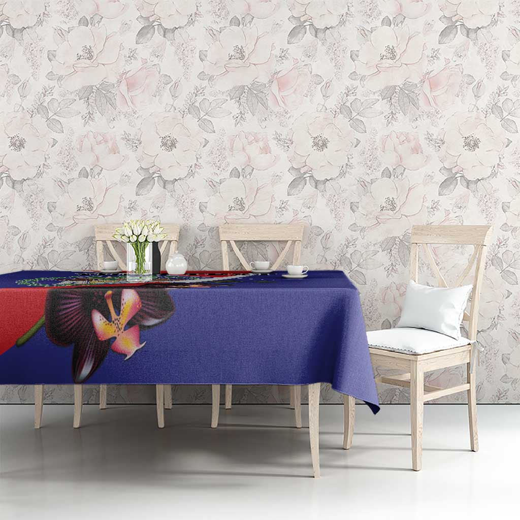 Blue tablecloth with orchid and coat of arms motif on dining table.