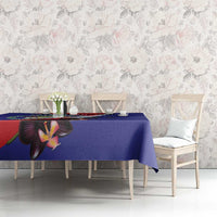 Blue tablecloth with orchid and coat of arms motif on dining table.