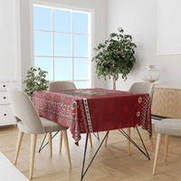 Red patterned Christmas tablecloth with geometric snowflake trim on a dining table
