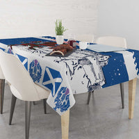 Blue holiday tablecloth draped on table, with crest and white X motifs