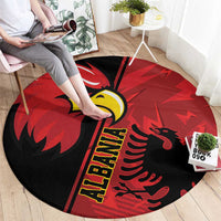 Round red eagle emblem rug, black center with yellow lettering and curled decorative shapes