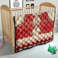 Beige quilt with red eagle motif and black/red geometric trim, crib bedding