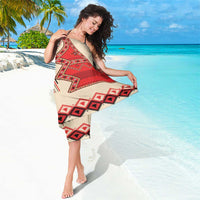Beige sarong cover-up with red, black, and white geometric motif print, tied wrap