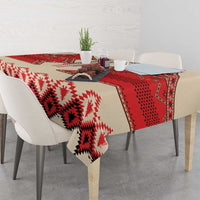 Beige tablecloth draped on table with red-and-white diamond and zigzag motifs