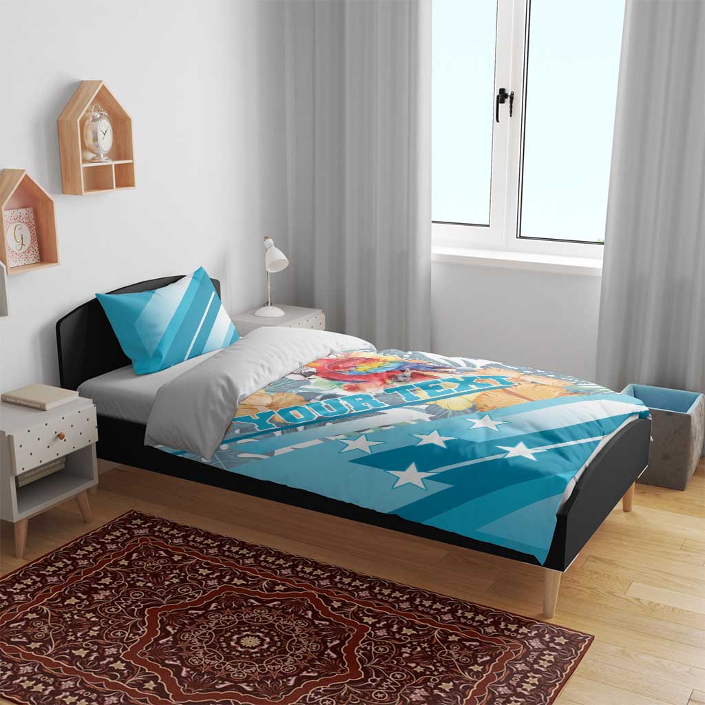 Blue bedding set on bed with parrot and hibiscus artwork, star-spangled stripes, duvet and pillows