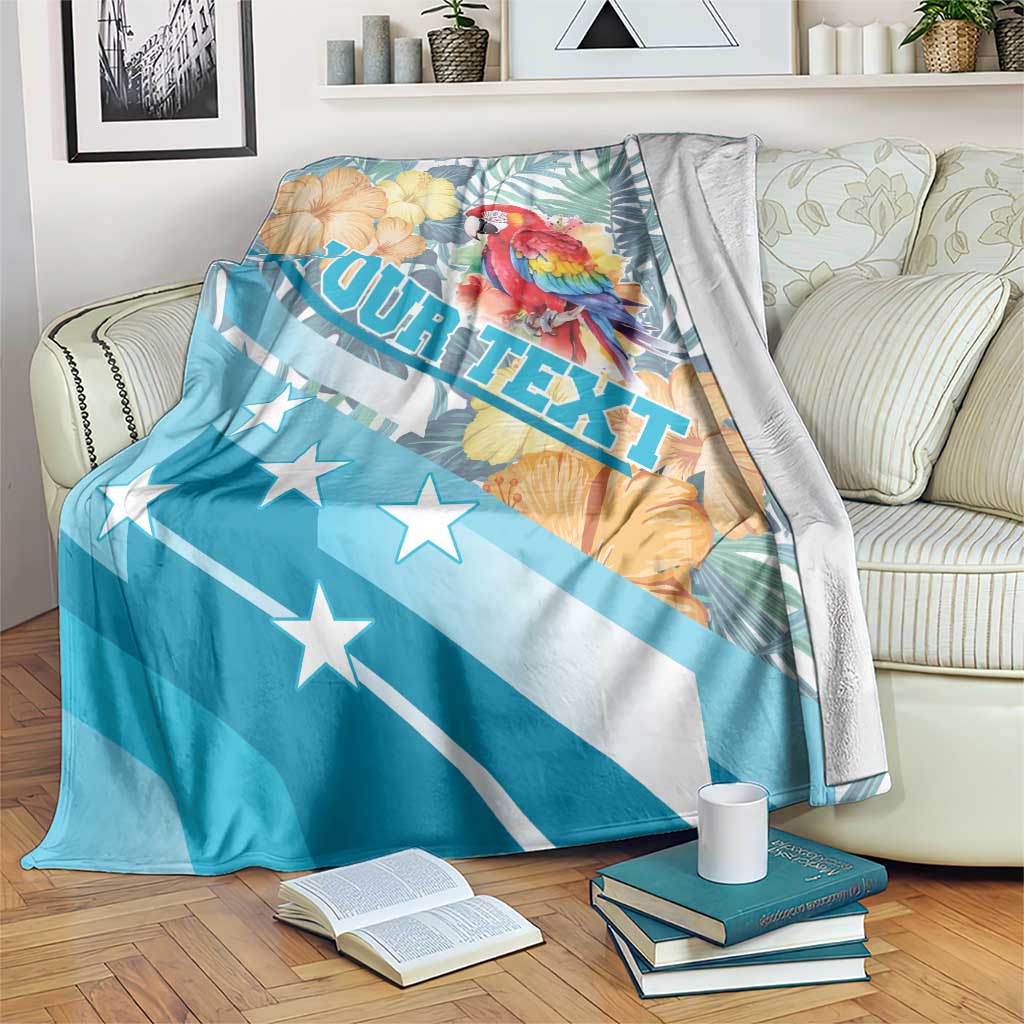 Personalized blue blanket with red macaw, flowers, and ROATAN text design