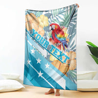 Personalized blue blanket featuring macaw, tropical leaves, flowers, and ROATAN banner
