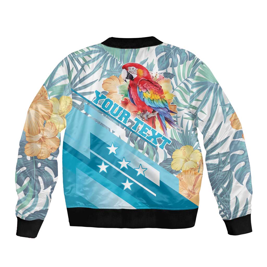 Unisex blue bomber jacket, back view with tropical leaves, red macaw and hibiscus flowers, ribbed hem