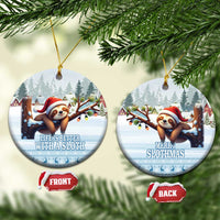 Blue ceramic sloth holiday ornament, round disc with Santa sloth and tree scene.