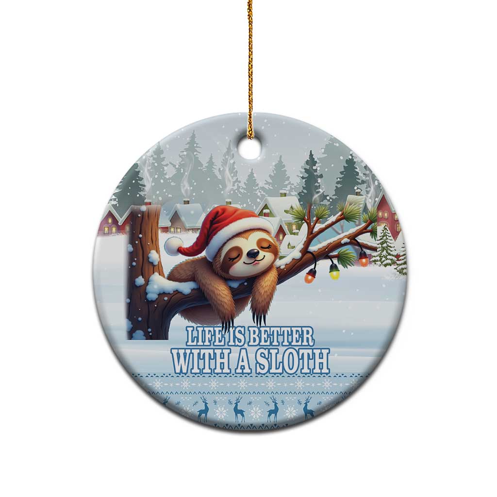 Blue ceramic round sloth ornament with hanging gold cord and snowy village artwork.