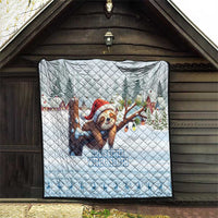 Blue quilt hanging on wooden wall with sloth in Santa hat, trees, and slogan