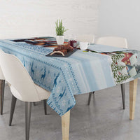 Blue patterned tablecloth with winter silhouettes and zigzag trim over tabletop