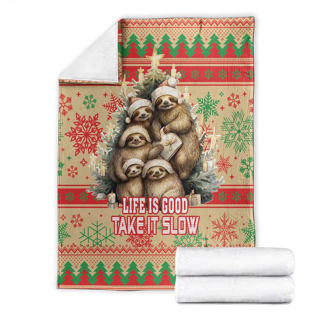 Red Christmas blanket with sloth graphic and 'Life is Good Take it Slow' text, with folded rolls