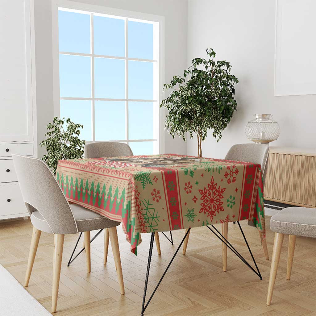 Red Christmas tablecloth with green trees, snowflakes, and geometric border on dining table