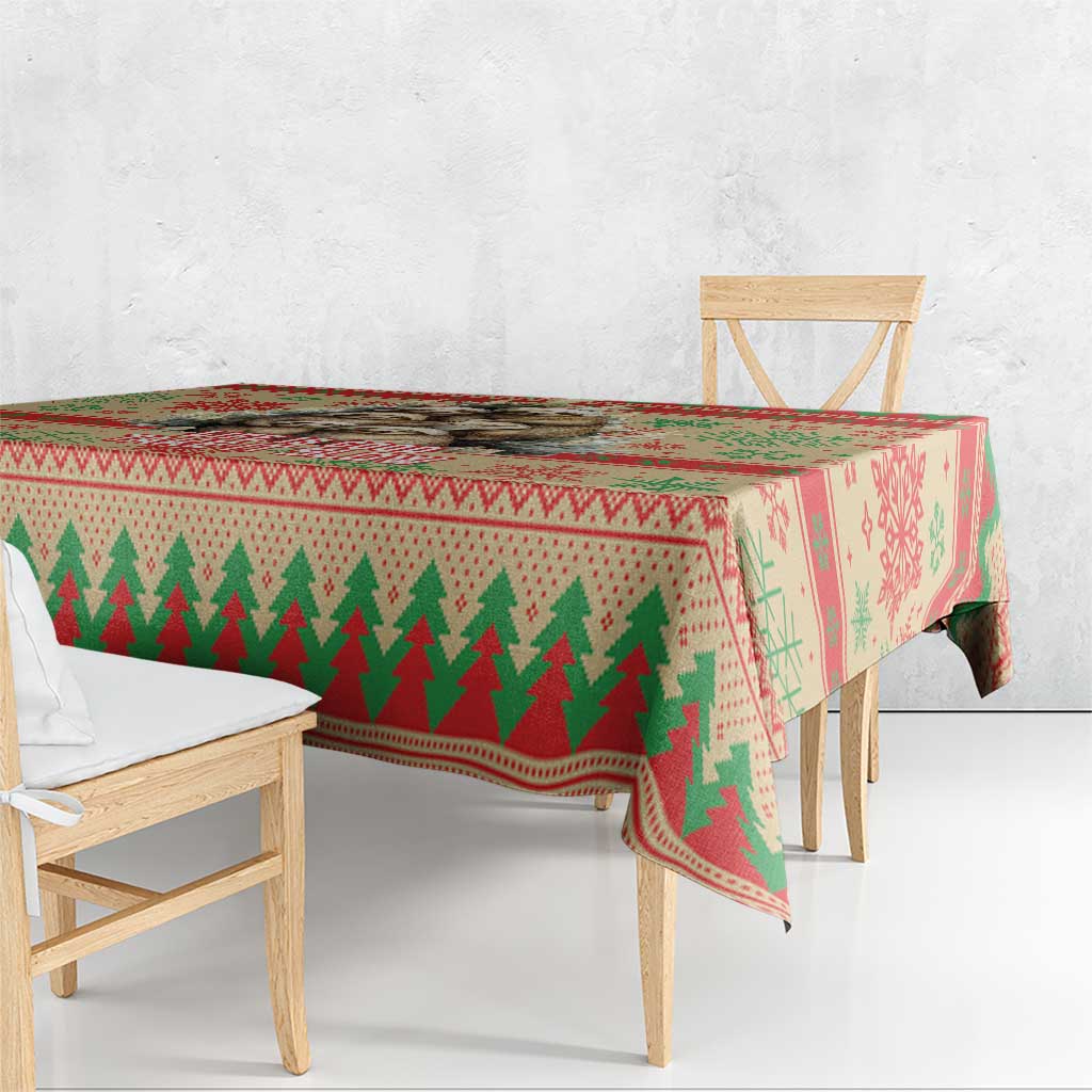 Red Christmas tablecloth with green tree stripe and snowflake border on wooden table