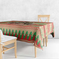 Red Christmas tablecloth with green tree stripe and snowflake border on wooden table