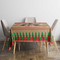 Red Christmas tablecloth with repeating green tree design and patterned trim