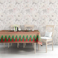 Red Christmas tablecloth with green tree row and snowflake trim on dining table