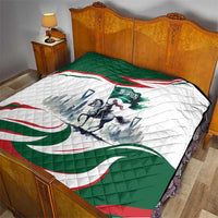 Quilted green and white throw with red wave border and horse rider emblem at center