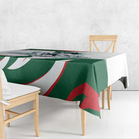 Green tablecloth with horse-rider graphic, red and white curved stripes, draped over table