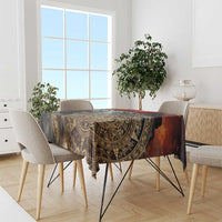 Dark gold Aztec tablecloth with bold warrior design, on dining table with chairs