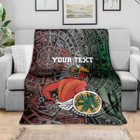 Personalized Aztec warrior blanket on sofa, Your Text over red and green tribal graphics.