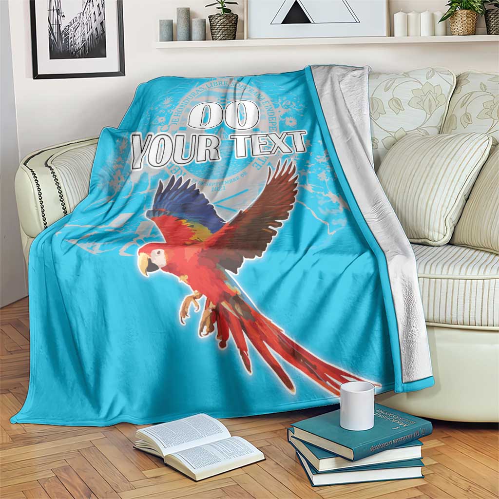 Blue blanket on couch with flying macaw graphic and customizable “YOUR TEXT”