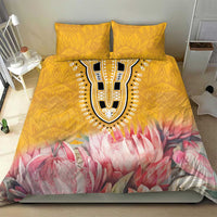 Yellow duvet cover with pink protea floral print and tribal-style central emblem, two pillows