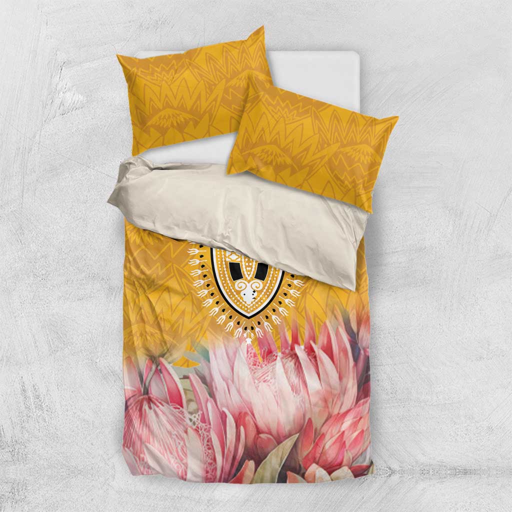 Folded yellow and pink bedding set with patterned medallion and two coordinating pillowcases