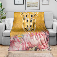 Yellow and pink floral king blanket with central patterned panel, folded on couch