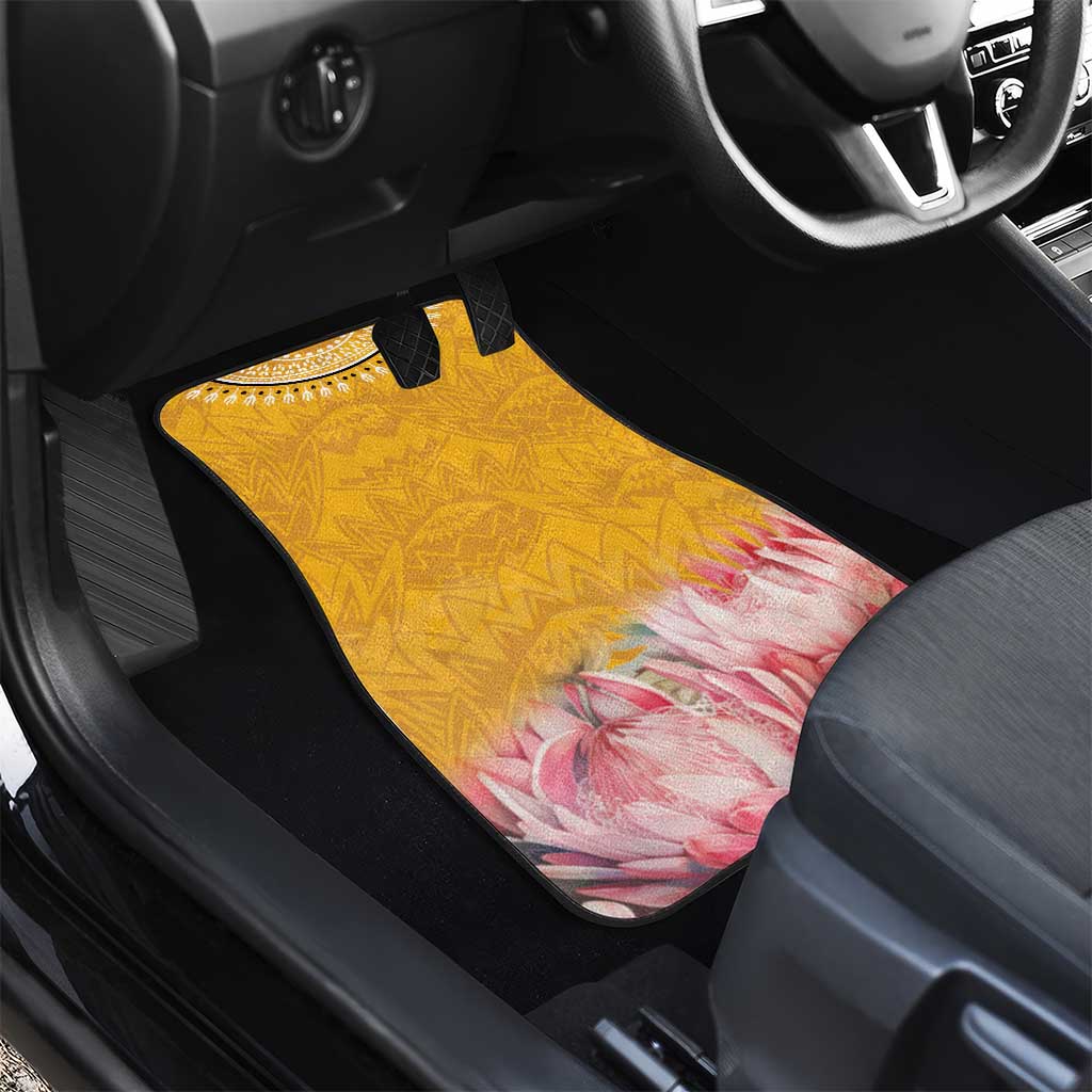 Close-up of yellow car floor mat with geometric design and pink floral protea motif