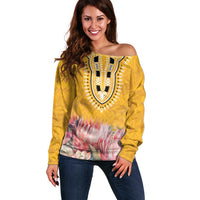 Yellow off-shoulder sweater with bold patterned yoke and pink floral hem