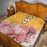 Yellow quilt bedding with pink floral print and ornate black-and-white dashiki centerpiece
