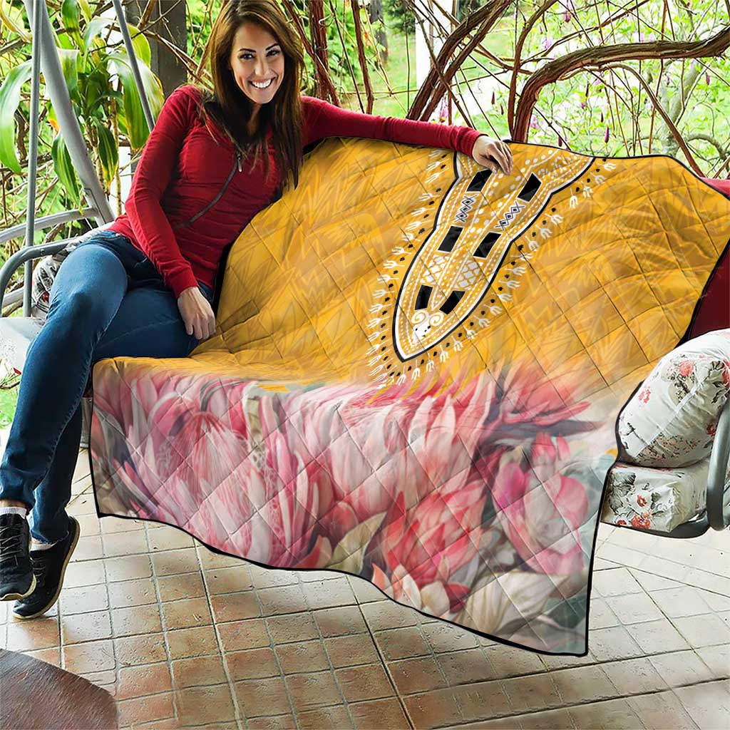 Yellow quilt with pink floral pattern and black-and-white dashiki medallion design