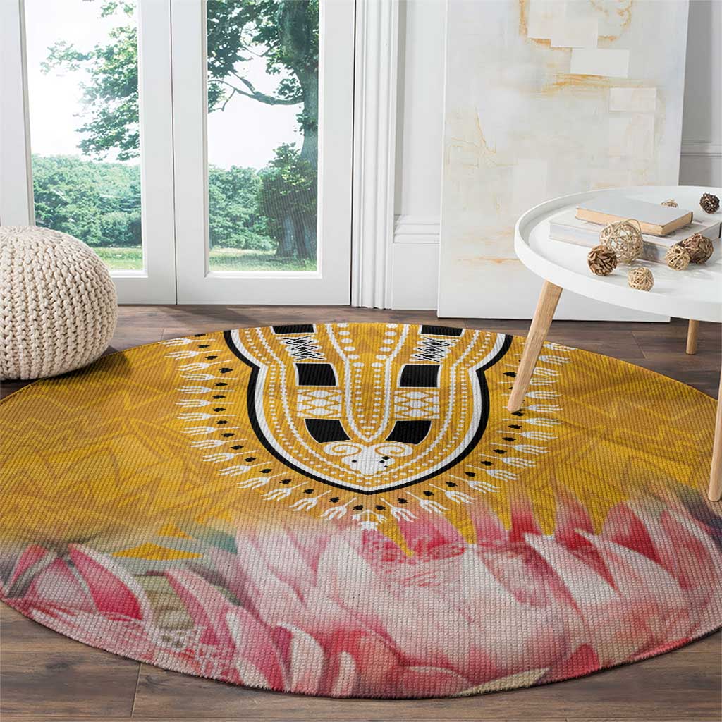 Round yellow floral rug with black medallion and pink feather-like petal motif