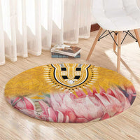 Round yellow and pink floral motif rug with black-and-white center medallion