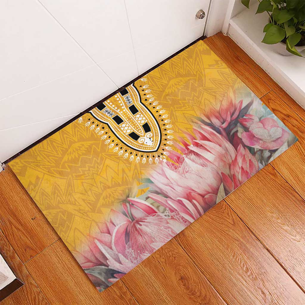 Yellow rubber doormat with black-and-white medallion and pink floral design in a corner