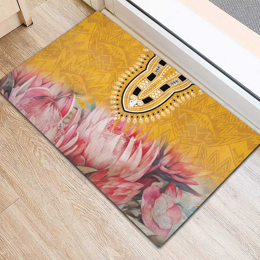 Yellow rubber doormat with tribal medallion and pink floral pattern, angled view