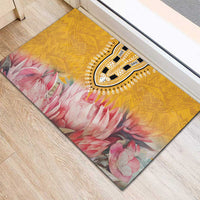 Yellow rubber doormat with tribal medallion and pink floral pattern, angled view