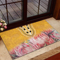 Yellow rubber doormat with black-and-white tribal medallion and pink floral pattern